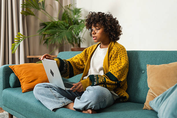 istock African American girl using laptop at home office typing chatting reading writing email. Young black woman having virtual meeting online chat video call conference. Work learning from home. 2242367647
