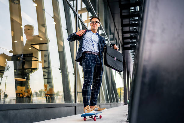 istock Young businessman riding skateboard carrying briefcase 2242367834