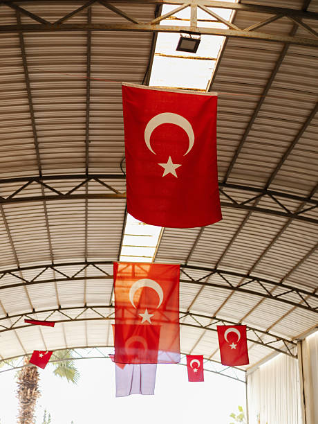 istock Colorful Turkish flags hang from the ceiling of a spacious hall, creating a festive atmosphere. The flags showcase the crescent moon and star emblem, symbolizing national pride 2242368398