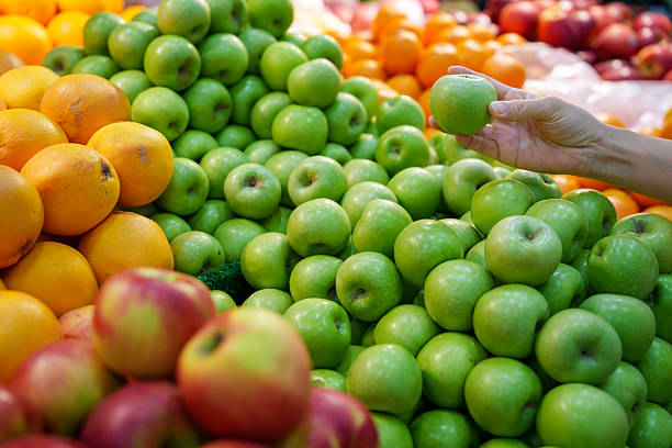 istock Person selecting fresh green apple at fruit market 2242368491