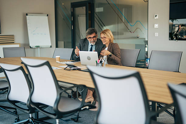 istock Business partners collaborating in meeting room using laptop 2242370963