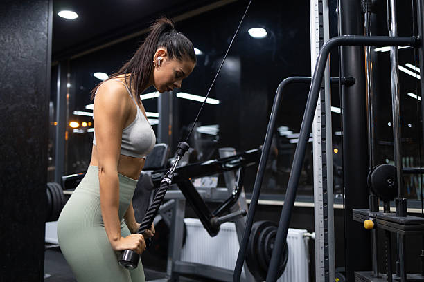 istock Female bodybuilder working out on exercise machine in gym. 2242371325