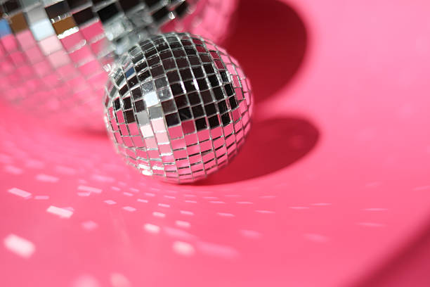 istock Closeup of Silver Disco ball on bright pink backdrop with room for copy space 2242373053