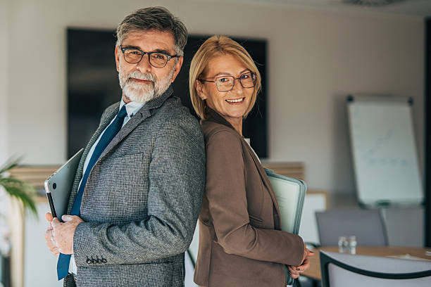 istock Business professionals standing back to back smiling in office 2242373504