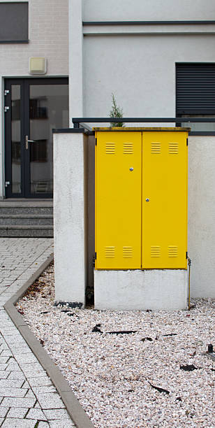 istock Bright yellow utility box stands out in modern urban setting with white gravel 2242376302