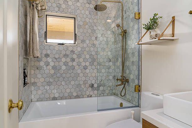 istock Modern bathroom in white with shower tub with hexagonal tile and brass 2242377727