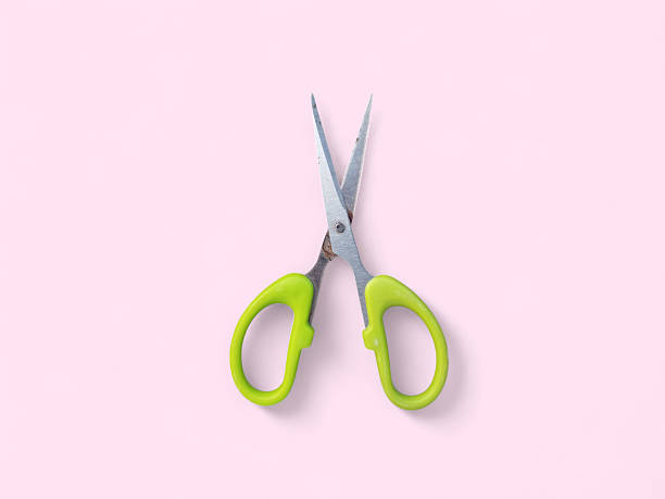 istock Bright Green Scissors on a Pink Background 2242381245