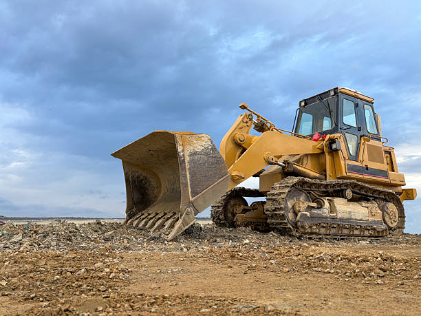 istock Bulldozer at a construction site with sky background. Construction machinery bulldozer, dozer. A bulldozer digging up the earth 2242381811
