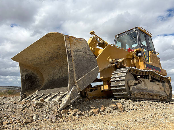 istock Bulldozer at a construction site with sky background. Construction machinery bulldozer, dozer. A bulldozer digging up the earth 2242381844