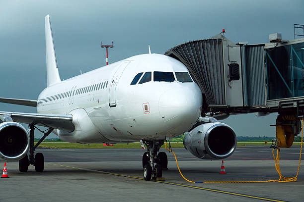 istock Charter airline airplane preparing for flight on airport runway with connected jet boarding bridge 2242386871