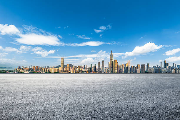 istock Empty clean asphalt ground with a wide panoramic view of the modern financial district skyline under a clear blue sky. 2242388012