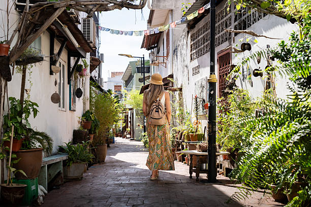 istock Woman exploring charming penang alley lined with potted plants 2242392434