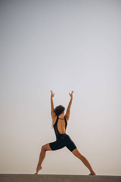 istock Athlete performs high-energy balance pose outdoors with raised arms, showcasing strength and focus 2242394755