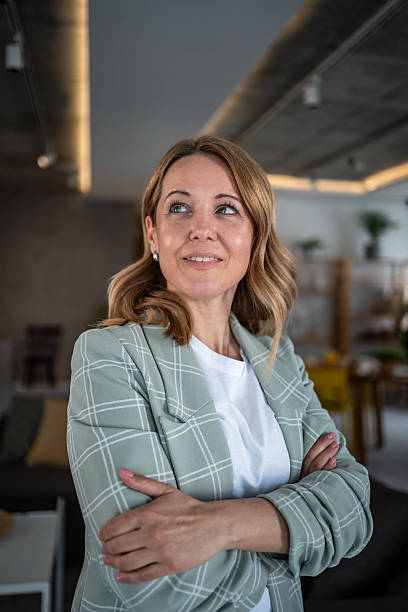 istock Confident businesswoman with arms crossed thinking about future 2242394833