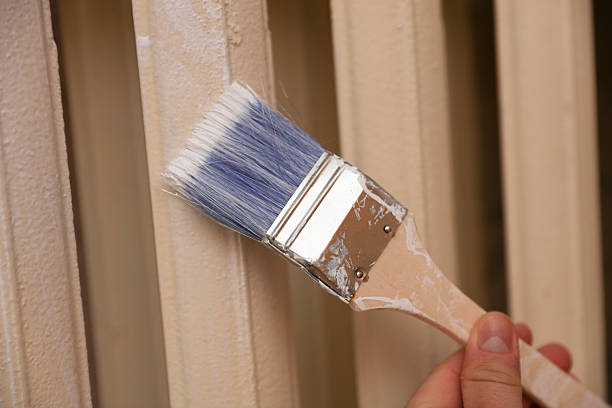 istock Painting old heating batteries with a brush 2242397569