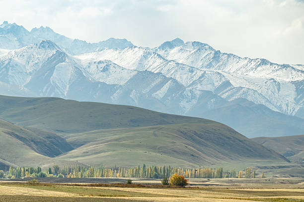 istock Panoramic  autumn view of mountain range with hills, pasture, and fields in foreground. 2242398569