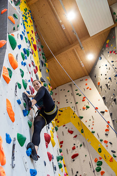 istock Climber Scaling Indoor Rock Climbing Wall 2242399353