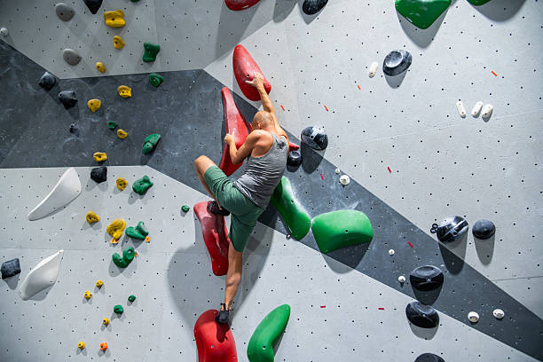 istock Indoor Bouldering Climber On Colorful Holds 2242400040