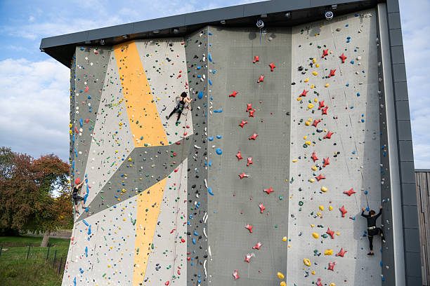 istock Climbers Scale Outdoor Climbing Wall Adventure Park 2242400106