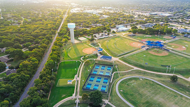 istock Lush area residential area, railroad, sport complex with walking paths, baseball fields, tennis courts active players. Trees, open space blend recreation with suburban planning, Highland Village 2242400563