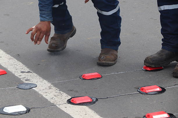 istock Road marking and maintenance work with paint, asphalt and reflective tacks 2242402828