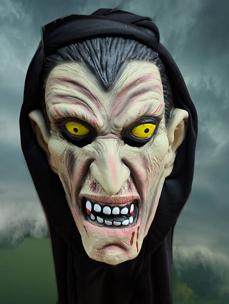 istock Scary witch mask with sharp teeth and yellow eyes displayed against an ominous cloudy backdrop 2242404501