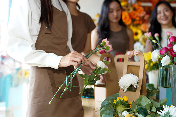 istock Diverse group of young people arranging flowers in florists workshop while attending class on floral art 2242405174