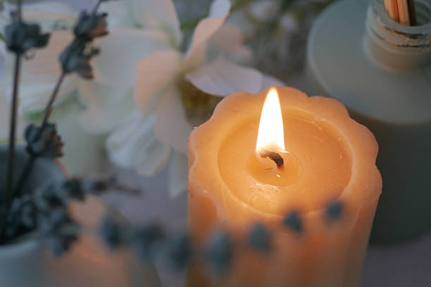 istock Elegant candle flickers surrounded by soft flowers 2242406524