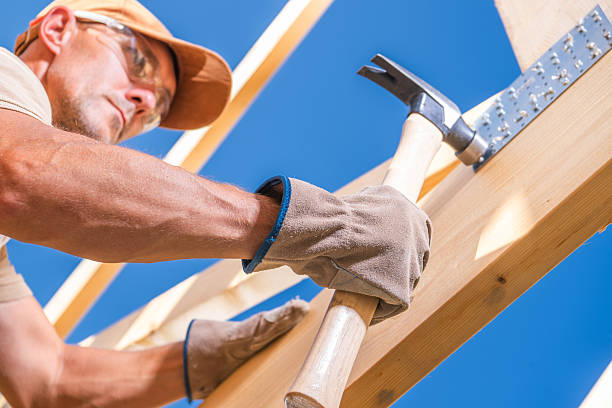 istock Skilled Carpenter Working on Wooden Structure Under Clear Blue Sky 2242406560