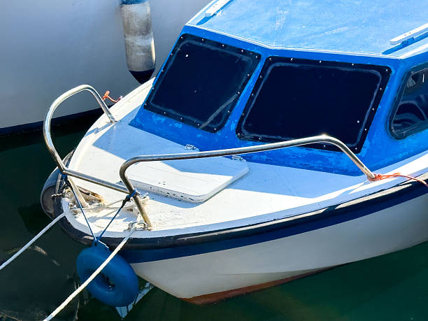 Small blue and white boat moored in sunlit harbor