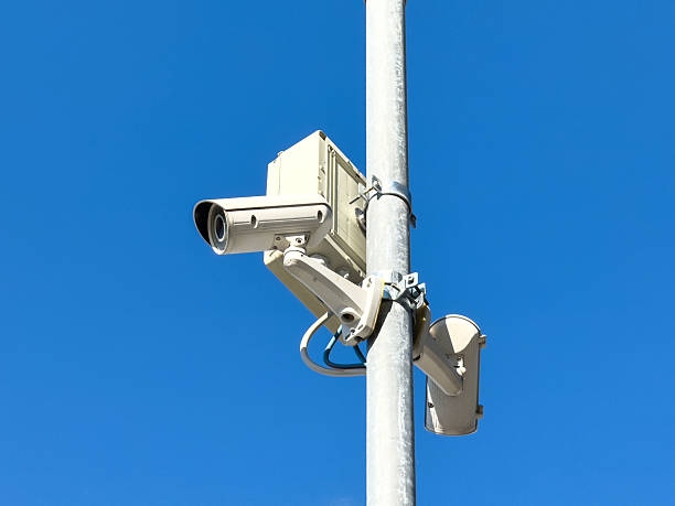 istock Outdoor security camera mounted on pole against clear blue sky 2242406828