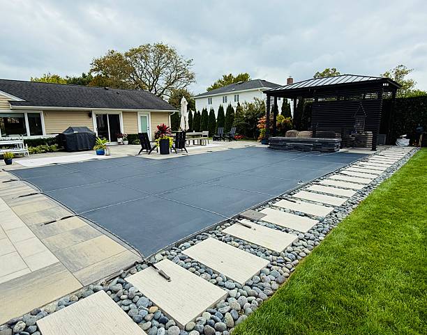 istock Ready for winter in fall. Custom winterized J-shaped built-in, inground pool with safety Loop - Loc mesh cover to protect. 2242407176