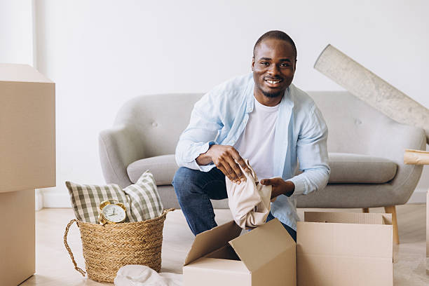 istock African man packing boxes, relocating to new home 2242408673