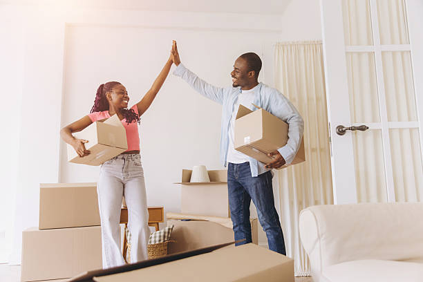 istock African American couple celebrating exciting moving day high five 2242409760