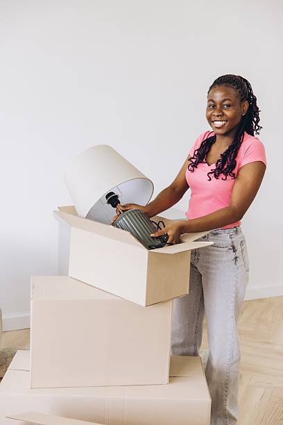istock African woman unpacking lamp during moving day 2242409907
