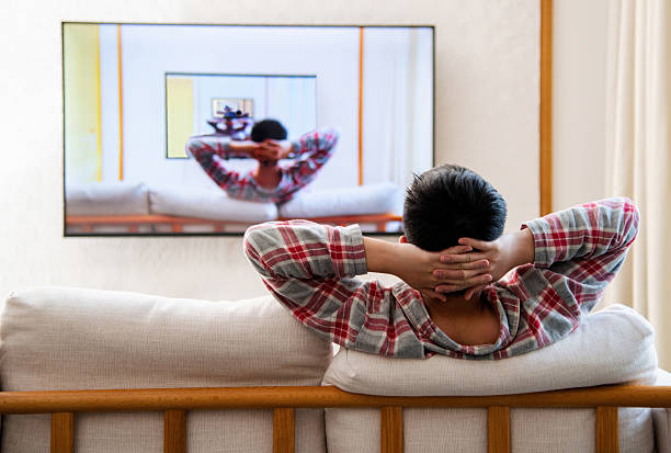 istock Teenage boy watching tv at home with same image in frame 2242409982