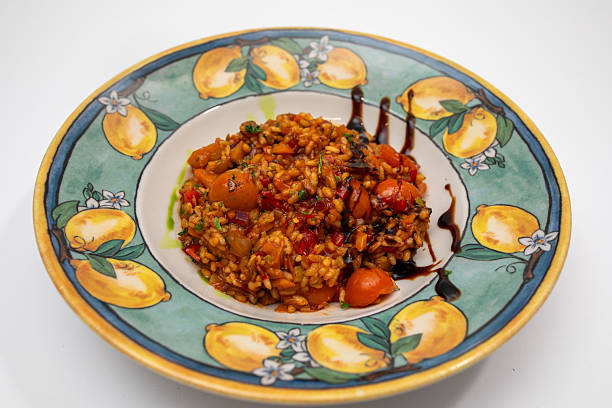 Colorful Rice Dish With Tomatoes, Vegetables, and Balsamic Drizzle on a Decorative Plate