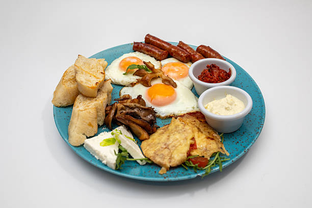 istock Brilliant Breakfast Platter With Eggs, Sausages, Bread, Cheese, And Sauces On Blue Plate 2242410206