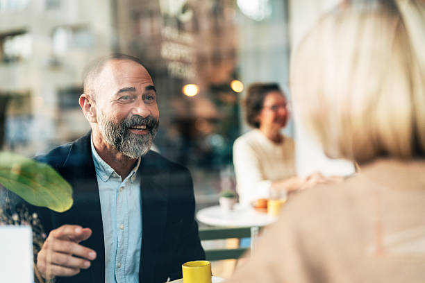 istock Mature business partners discussing ideas over coffee 2242412279