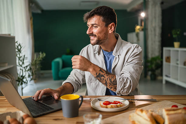 istock Man enjoying healthy breakfast while working on laptop at home 2242412942
