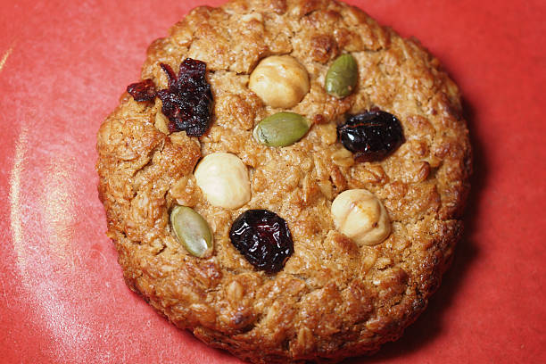 istock Oatmeal cookie with nuts and dried fruit on red background 2242415050