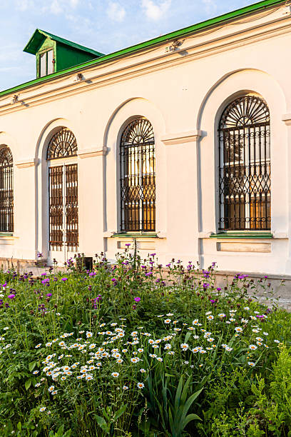 istock White building with arched windows surrounded by vibrant flowers in a sunny garden setting 2242416605