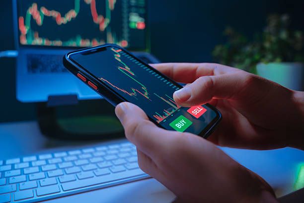 istock Trader hands using mobile trading app at night, buying crypto or stocks 2242417619
