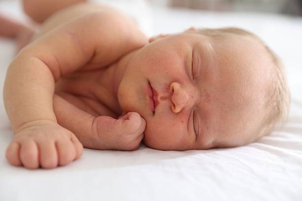 istock Cute newborn baby sleeping on bed indoors 2242421475