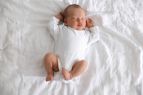 istock Cute newborn baby sleeping on bed, top view 2242421506