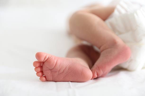 istock Cute newborn baby lying on bed, closeup 2242421556