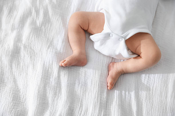 istock Cute newborn baby lying on bed indoors, top view. Space for text 2242421559