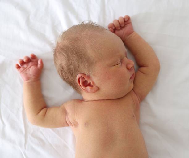 istock Cute newborn baby sleeping on bed, top view 2242421572