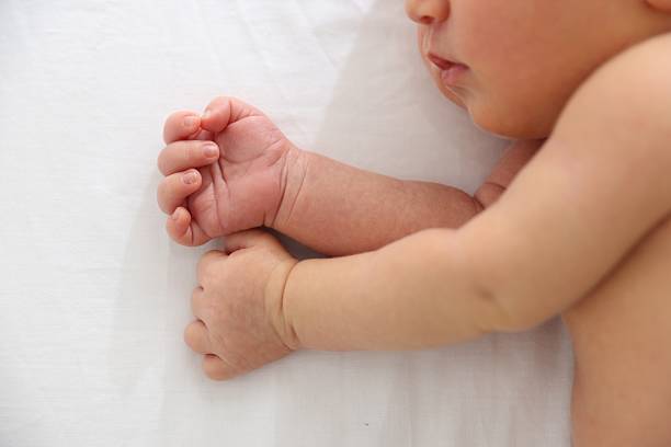 Cute newborn baby lying on bed, top view