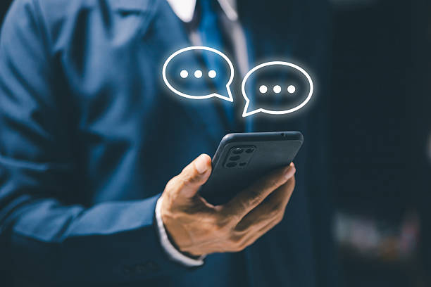istock A businessman holding smartphone with chat message hologram, representing online communication, social media connection, business messaging, and digital interaction technology. 2242421828